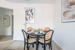 a dining room with a black table and chairs at Lovely City Apartments in Vibrant Area of Copenhagen in Copenhagen