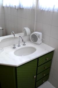 baño con lavabo y ventilador en la encimera en Apartamento Central, en Gramado