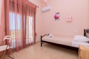 a small bedroom with a bed and a window at Thea Dikella in Dhíkella