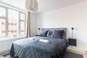 a bedroom with a large bed with two towels on it at Lovely City Apartments in Vibrant Area of Copenhagen in Copenhagen