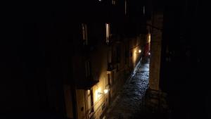 an empty alley at night with lights on at La Maison del Duomo in Catania