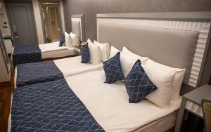 two beds in a hotel room with blue and white pillows at Mineo Park Hotel in Istanbul