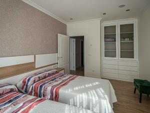 a bedroom with a bed and a dresser at Lujo a estrenar con piscina cubierta in Teo +19 photos