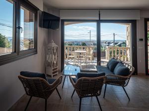 a living room with a table and chairs and a balcony at Lujo a estrenar con piscina cubierta in Teo