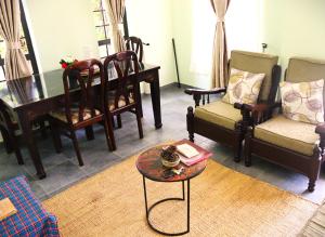 een woonkamer met stoelen, een tafel en een piano bij My Moka Arusha in Arusha +28 foto's