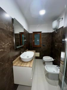 a bathroom with two sinks and two toilets at Patricia's Apartment in Striano +4 photos