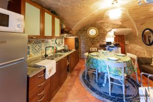 a kitchen with a table with chairs and a sink at A Casa di Rache & Bea in Volterra
