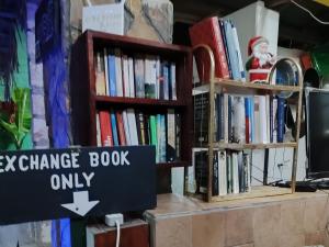 a book shelf with books on it with a christmas sign at HOMELAND SWAHILI LODGE Nungwi Backpacker Apartments BUDGET in Nungwi