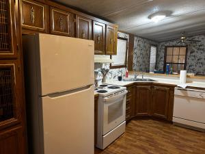 a kitchen with a white refrigerator and wooden cabinets at Woolen Lake House in Columbia