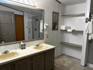 a bathroom with two sinks and a large mirror at Woolen Lake House in Columbia