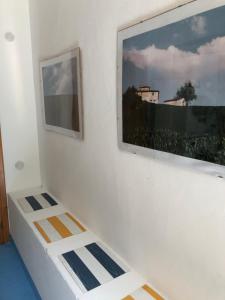 a white wall with a picture on the wall at Casa Spisidda Appartamento monolocale "Vulcano" per 4 persone con vista sulle Eolie in Gioiosa Marea