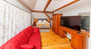 a living room with a red couch and a flat screen tv at Palmse Manor Guesthouse - Self Check-in in Palmse