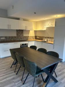 a kitchen with a wooden table and four chairs at Appartement op een boerderij met eigen tuin in Tuk