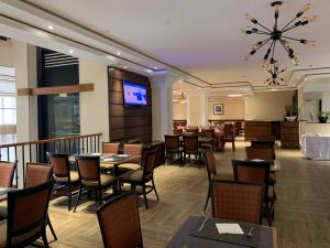 a restaurant with tables and chairs and a flat screen tv at The HUB Hotel in Addis Ababa