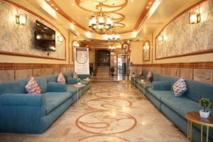 a lobby with blue couches and tables and a television at فندق برادايس نيس النزهة Paradise Nice Hotel in Mecca