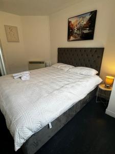 una camera da letto con un letto grande con lenzuola bianche di Victoria Street View Flat in Edinburgh EB10 a Edimburgo