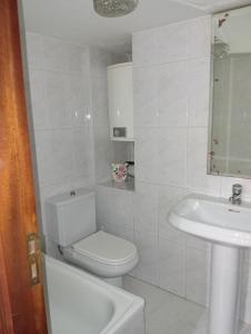 Un baño blanco con inodoro y lavabo. en Casa da laxe, en Combarro 14 fotos más