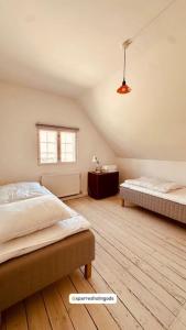 a bedroom with two beds and a window at Gatekeepers house in Svennerup