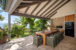 een terras met een houten tafel en stoelen bij Villa L'orizzonte in Slatine