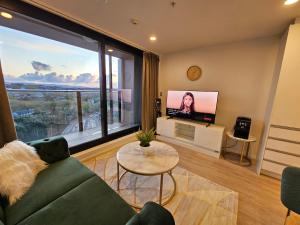 a living room with a couch and a large window at Urban Retreat - Central Auckland Stay in Auckland