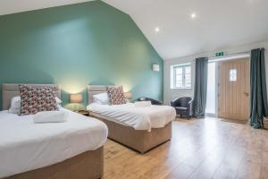 剑桥TWIN Deluxe Disabled Access and Wet Room with Courtyard View - Newton的一间卧室配有两张床和椅子