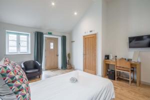 剑桥TWIN Deluxe Disabled Access and Wet Room with Courtyard View - Newton的一间卧室，配有一张床和一张带电脑的书桌