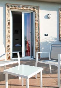 two white chairs and a table in front of a door at B&B Il Giardino di Circe - Filadelfia (VV) in Filadelfia