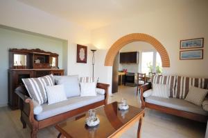 a living room with two couches and a table at Elya in Prínos