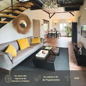 an open living room with a couch and a table at Jolie petite maison - Entre mer, montagne, Espagne in Jurançon
