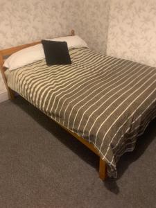 a bed with a black and white striped blanket at The New Macleods Guest House in Blackpool
