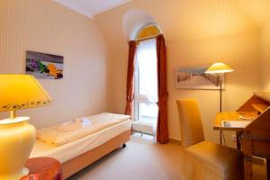 a small bedroom with a bed and a window at Strandhotel Sylt Westerland in Westerland