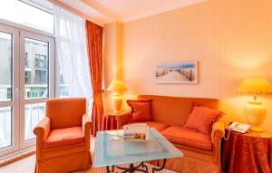 a living room with a couch and a table at Strandhotel Sylt Westerland in Westerland