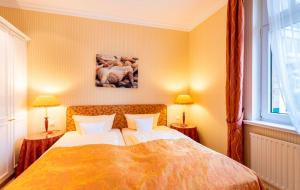 a bedroom with a bed with two lamps and a window at Strandhotel Sylt Westerland in Westerland