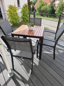 a wooden table and two chairs on a deck at Ferienwohnung Krämer bei Rothenburg ob der Tauber in Gebsattel