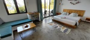a bedroom with a bed and a table and a couch at Villa Ti Zil in Rodrigues Island