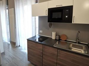 a kitchen with a sink and a microwave at Casa Belfiore Vicenza Medici 23 in Vicenza
