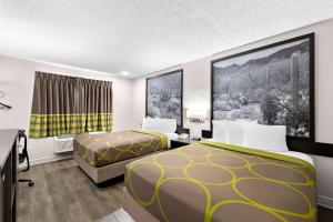 a hotel room with two beds and a television at Super 8 by Wyndham Goodyear/Phoenix Area in Goodyear +37 photos