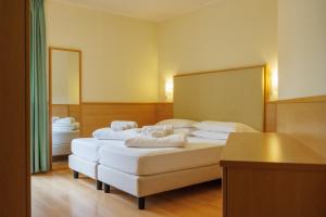 Łóżko lub łóżka w pokoju w obiekcie Club Hotel e Residence La Vela