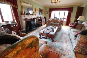 a living room with couches and a fireplace at Mossvale Lodge Country House Bed and Breakfast in Antrim