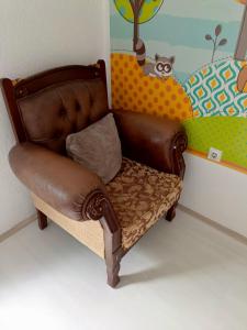 a brown leather chair in a childs room at Historia Hostel in Skopje