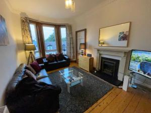 a living room with a couch and a fireplace at Scotstoun Appartments in Glasgow