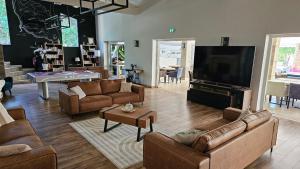 a living room with couches and a flat screen tv at La madone in La Tour-dʼAigues