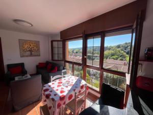 een woonkamer met een tafel en een groot raam bij La Cardosa in Comillas +15 foto's
