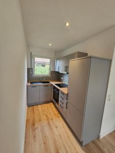 a kitchen with stainless steel appliances and wooden floors at Harlehaus Nina in Friedrichsschleuse