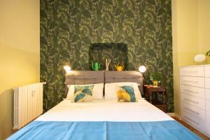 a bedroom with a bed with a green wall at Parco Vittadini Apartment in Milan