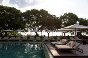 a swimming pool with lounge chairs and umbrellas next to a pool at Hotel Miramar Barcelona GL in Barcelona