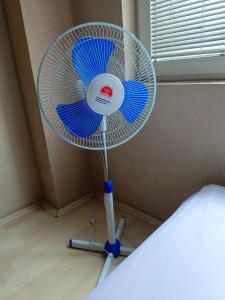 a blue and white fan in a corner of a room at Historia Hostel in Skopje