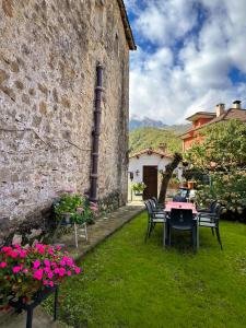 a garden with a table and chairs next to a building at Casa Rural El Torrejon in Arenas de Cabrales
