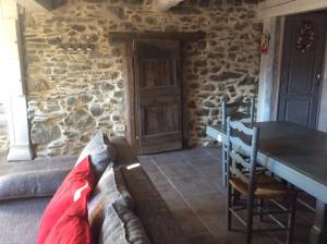a room with a table and a stone wall at Chalet confortable à Ascou avec vue sur la montagne in Ascou