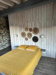 a bedroom with a wooden wall with a bed with yellow cushions at Chalet confortable à Ascou avec vue sur la montagne in Ascou +14 photos